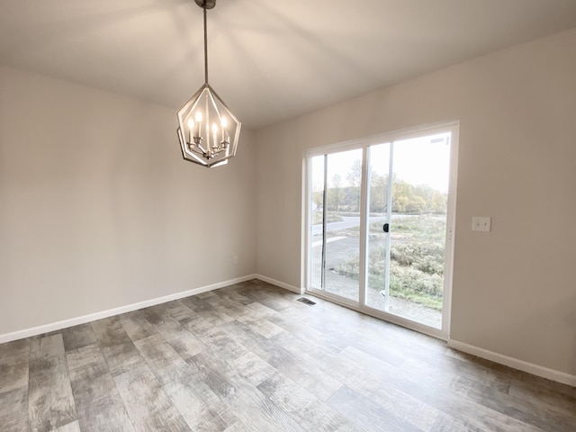 4272 Butternut Dr, Wayland, MI 49348 - spare room featuring wood finished floors, a chandelier, and baseboards