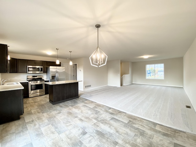 4272 Butternut Dr, Wayland, MI 49348 - kitchen featuring appliances with stainless steel finishes, a kitchen island, light countertops, open floor plan, and a sink