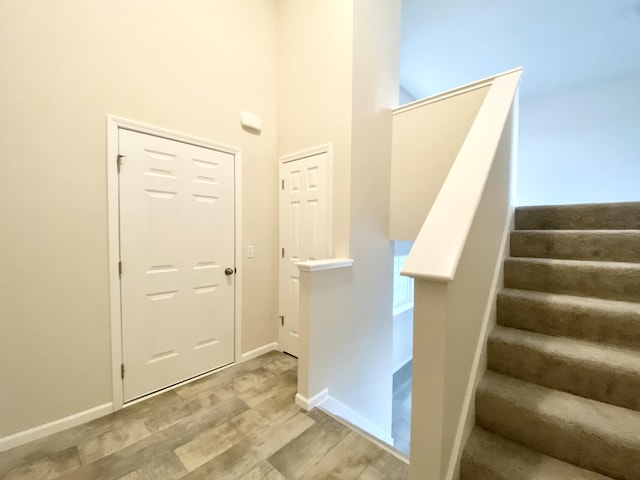 4272 Butternut Dr, Wayland, MI 49348 - stairway with wood finished floors, a high ceiling, and baseboards