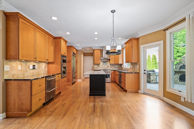 3265 Estates Dr, Saint Joseph, MI 49085 - kitchen with premium appliances, wall chimney range hood, crown molding, decorative backsplash, and brown cabinetry