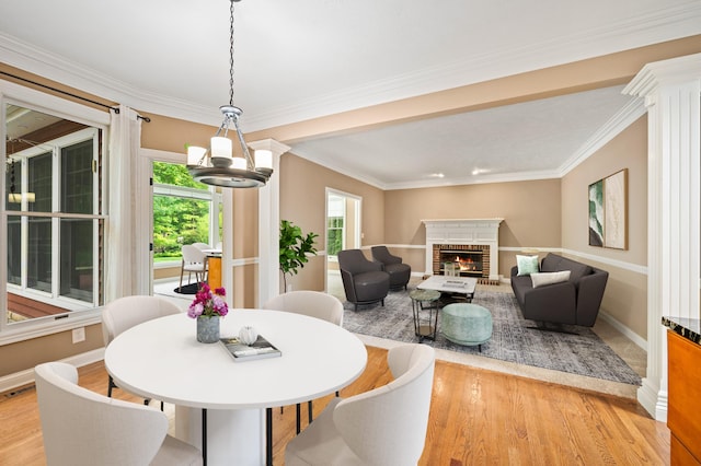 3265 Estates Dr, Saint Joseph, MI 49085 - dining space with light wood finished floors, a chandelier, a brick fireplace, baseboards, and ornamental molding