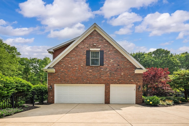 3265 Estates Dr, Saint Joseph, MI 49085 - view of side of home featuring a garage, concrete driveway, and brick siding