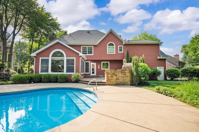3265 Estates Dr, Saint Joseph, MI 49085 - back of house with an outdoor pool, a wooden deck, a shingled roof, and a patio