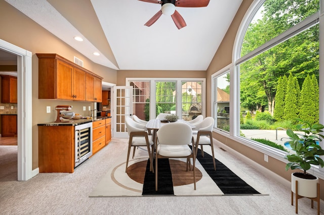 3265 Estates Dr, Saint Joseph, MI 49085 - kitchen with beverage cooler, light colored carpet, vaulted ceiling, a ceiling fan, and brown cabinetry