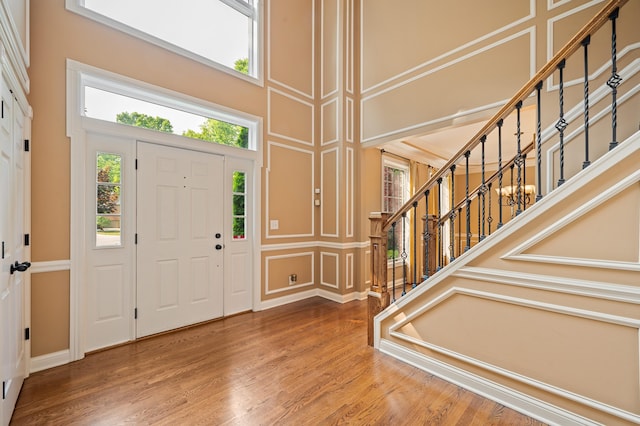 3265 Estates Dr, Saint Joseph, MI 49085 - entryway featuring a decorative wall, a high ceiling, stairs, and wood finished floors