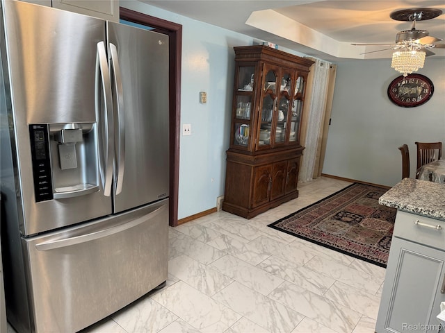 30347 Dell Ln, Warren, MI 48092 - kitchen with stainless steel fridge, light marble finish floors, ceiling fan, baseboards, and a tray ceiling