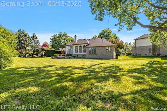 13815 Silent Woods Dr, Shelby Twp, MI 48315 - back of property featuring brick siding, a chimney, and a yard