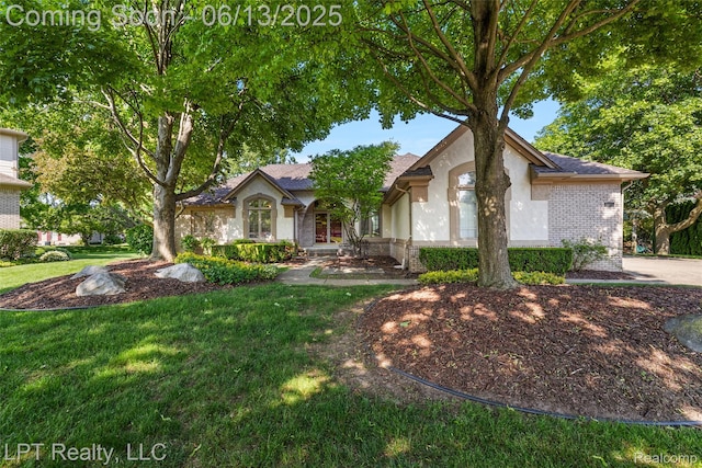 13815 Silent Woods Dr, Shelby Twp, MI 48315 - view of front of home featuring stucco siding, a front lawn, and brick siding