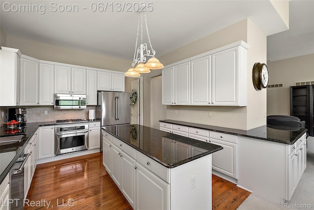 13815 Silent Woods Dr, Shelby Twp, MI 48315 - kitchen featuring appliances with stainless steel finishes, a center island, white cabinets, wood finished floors, and backsplash