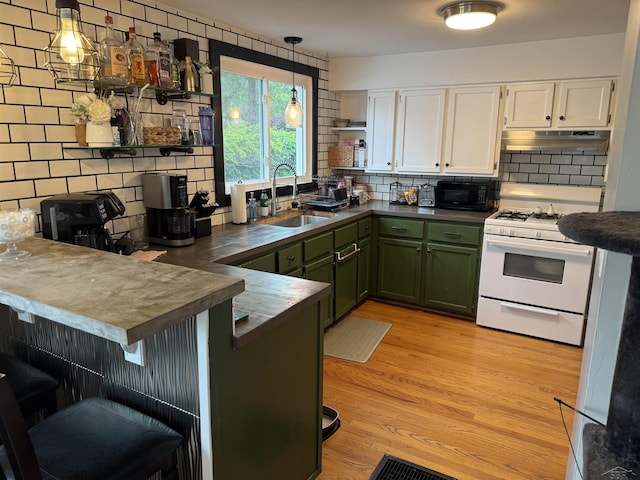 227 Mckinley Rd, Flushing, MI 48433 - kitchen featuring a sink, green cabinets, black microwave, and dark countertops