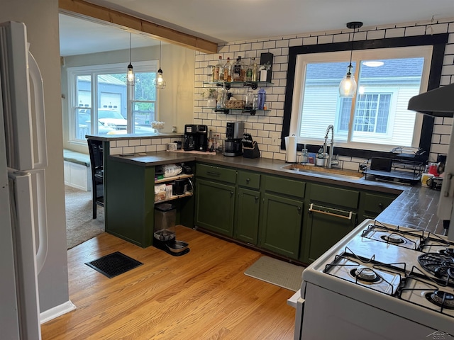 227 Mckinley Rd, Flushing, MI 48433 - kitchen with green cabinets, white appliances, a sink, dark countertops, and beamed ceiling