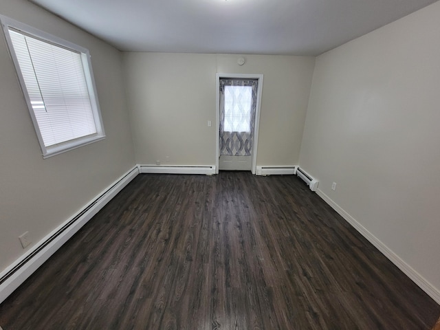 214 Arthur St, Manistee, MI 49660 - empty room with dark wood-style flooring, baseboards, and a baseboard radiator