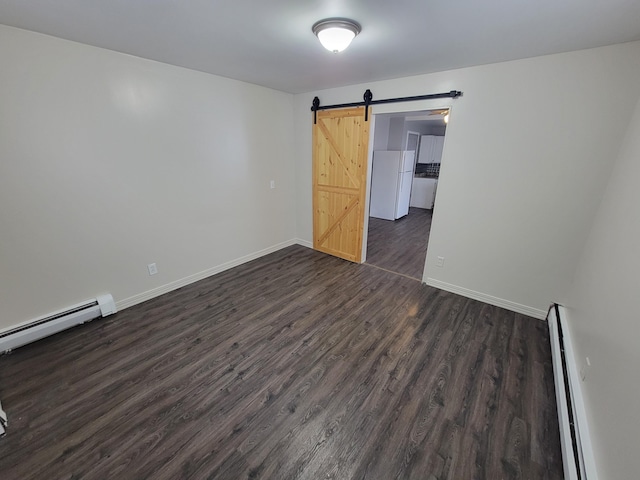 214 Arthur St, Manistee, MI 49660 - unfurnished room featuring baseboard heating, dark wood-type flooring, baseboards, and a barn door