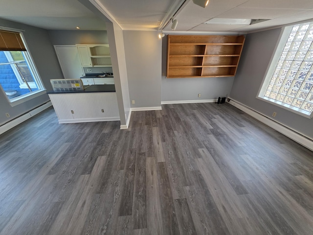 214 Arthur St, Manistee, MI 49660 - unfurnished living room featuring dark wood-type flooring, a sink, baseboards, and a baseboard heating unit