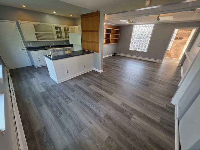 214 Arthur St, Manistee, MI 49660 - kitchen with a baseboard radiator, dark countertops, open shelves, dark wood-style floors, and open floor plan