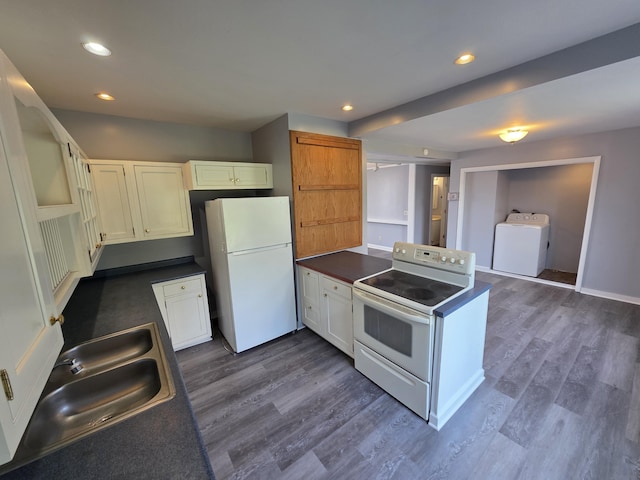 214 Arthur St, Manistee, MI 49660 - kitchen with white appliances, washer / clothes dryer, a peninsula, dark countertops, and a sink