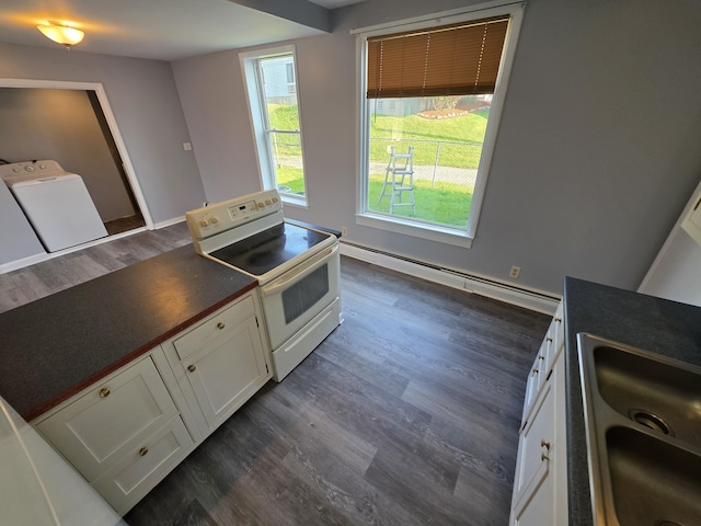 214 Arthur St, Manistee, MI 49660 - kitchen with white range with electric cooktop, a baseboard heating unit, dark wood-style floors, white cabinetry, and dark countertops