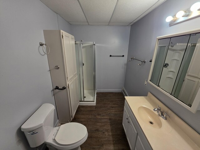 214 Arthur St, Manistee, MI 49660 - bathroom featuring a stall shower, vanity, wood finished floors, baseboard heating, and toilet