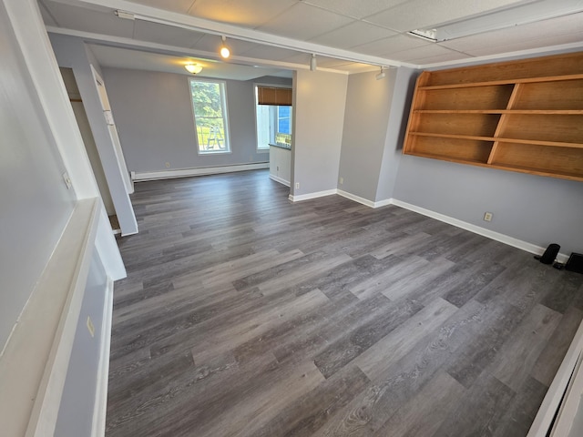 214 Arthur St, Manistee, MI 49660 - spare room with baseboard heating, dark wood-style floors, and baseboards