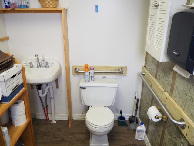 214 Arthur St, Manistee, MI 49660 - bathroom featuring wood finished floors, toilet, and baseboards