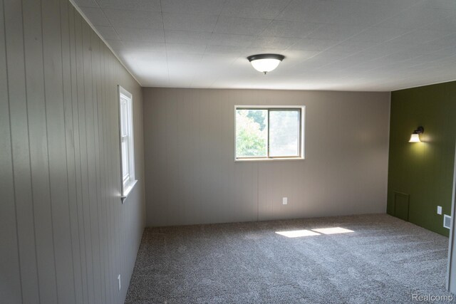 1247 Catalina Dr, Flint, MI 48507 - carpeted empty room with wood walls