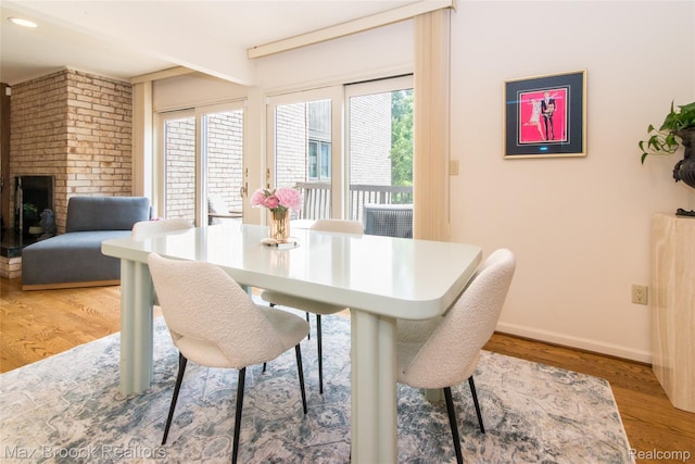 41350 Woodward Ave, Bloomfield Hills, MI 48304 - dining area featuring light wood-style flooring, baseboards, and a fireplace