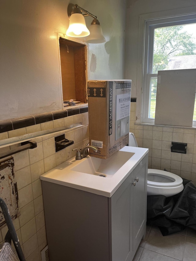 19188 Pelkey St, Detroit, MI 48205 - bathroom featuring tile walls, plenty of natural light, tile patterned flooring, vanity, and toilet