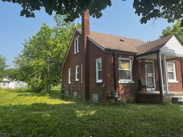 19188 Pelkey St, Detroit, MI 48205 - view of home's exterior featuring a chimney, brick siding, a lawn, and a shingled roof