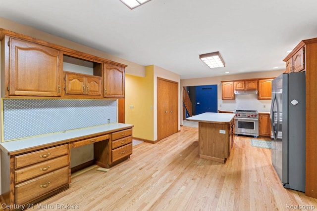 751 River Edge Ct, Flushing, MI 48433 - kitchen with stainless steel appliances, under cabinet range hood, built in study area, light wood finished floors, and light countertops