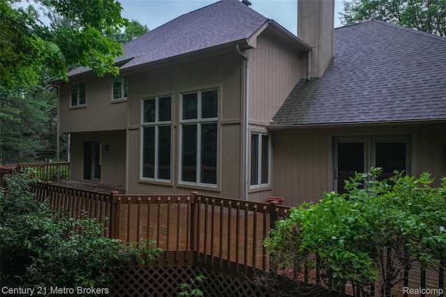 751 River Edge Ct, Flushing, MI 48433 - view of side of property with roof with shingles, a chimney, and a wooden deck