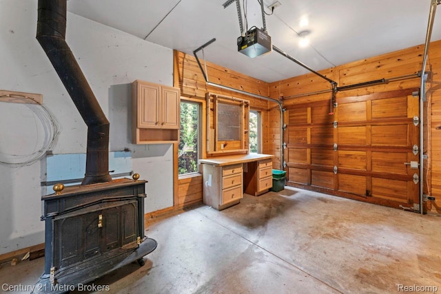 751 River Edge Ct, Flushing, MI 48433 - garage featuring a wood stove, a garage door opener, and wooden walls