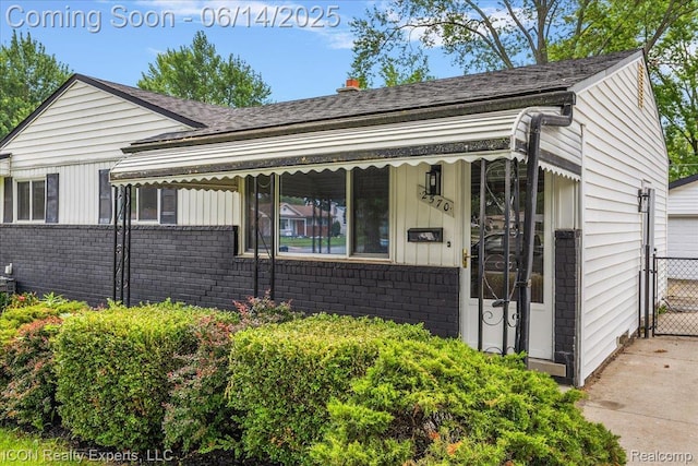 2570 Tarry Dr, Macomb, MI 48310 - view of front facade with brick siding, roof with shingles, and a gate