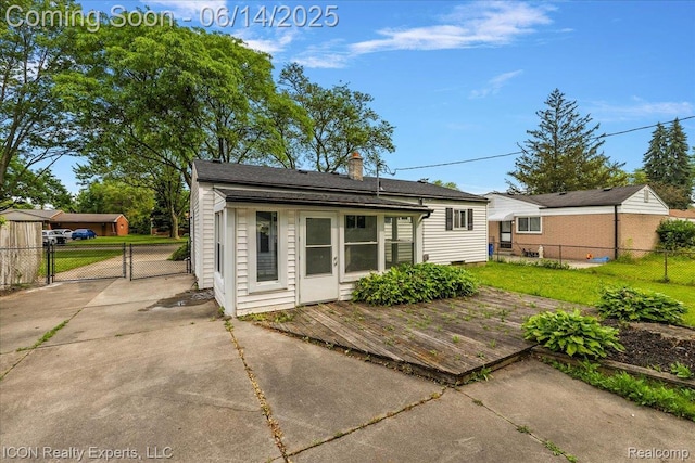 2570 Tarry Dr, Macomb, MI 48310 - back of property featuring a wooden deck, a gate, and a chimney