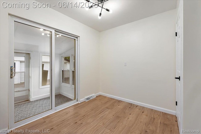 2570 Tarry Dr, Macomb, MI 48310 - spare room with light wood-style flooring, baseboards, and a chandelier