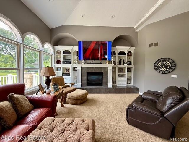 5415 Walker Rd, Davison, MI 48423 - carpeted living area featuring built in features, a tile fireplace, and high vaulted ceiling