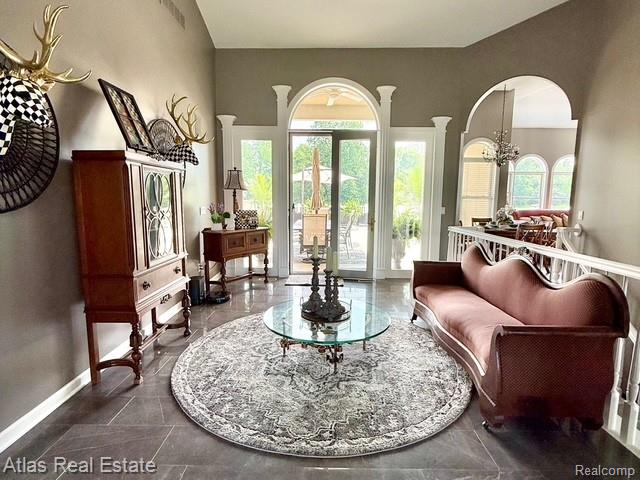 5415 Walker Rd, Davison, MI 48423 - living room featuring arched walkways, baseboards, and a chandelier