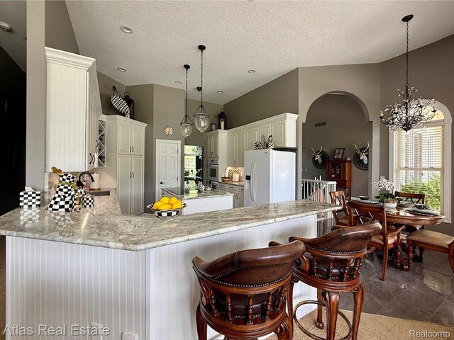 5415 Walker Rd, Davison, MI 48423 - kitchen featuring white refrigerator with ice dispenser, a peninsula, oven, arched walkways, and a sink