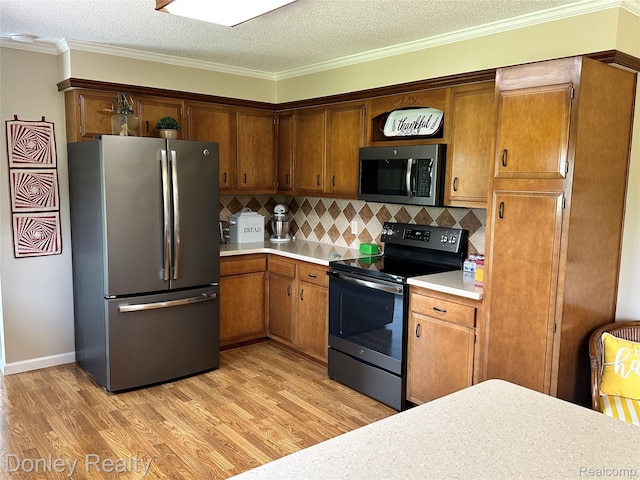 250 N Decker Rd, Snover, MI 48727 - kitchen featuring appliances with stainless steel finishes, light countertops, light wood-style floors, backsplash, and crown molding