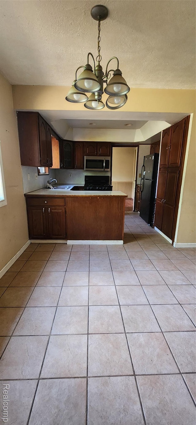 7040 Banks, Waterford, MI 48327 - kitchen with freestanding refrigerator, stainless steel microwave, a peninsula, a chandelier, and light tile patterned floors