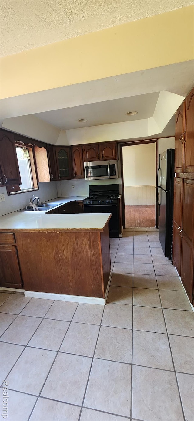 7040 Banks, Waterford, MI 48327 - kitchen featuring black appliances, a peninsula, light tile patterned flooring, light countertops, and a textured ceiling