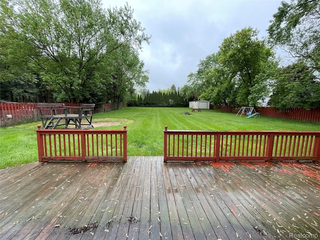 7040 Banks, Waterford, MI 48327 - wooden terrace with a shed, a fenced backyard, and a playground
