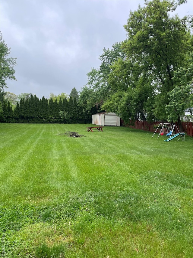 7040 Banks, Waterford, MI 48327 - view of yard featuring a garage, a shed, and a playground