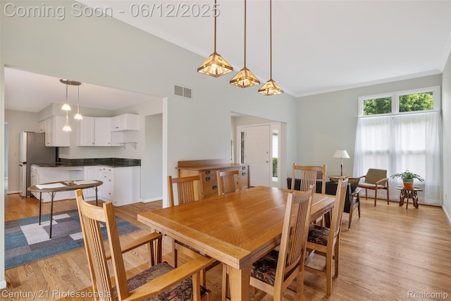 11213 Youngstree Ct, Davisburg, MI 48350 - dining space with light wood-style flooring, baseboards, vaulted ceiling, and crown molding