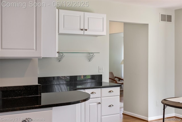 11213 Youngstree Ct, Davisburg, MI 48350 - kitchen with white cabinetry, dark countertops, wood finished floors, and baseboards