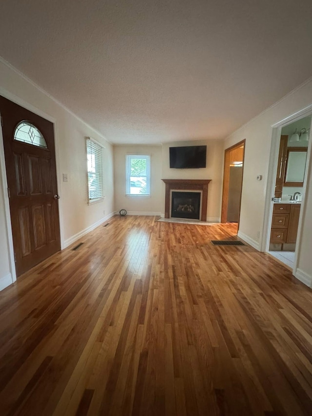 829 S Union St, Tecumseh, MI 49286 - unfurnished living room with wood-type flooring, a fireplace with flush hearth, and baseboards