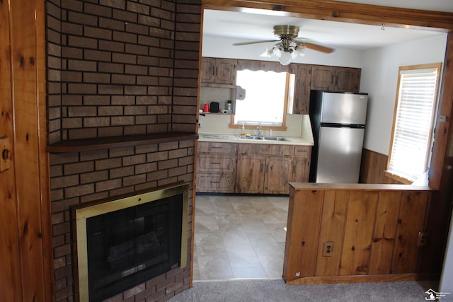 653 Huber Dr, Monroe, MI 48162 - kitchen featuring freestanding refrigerator, a brick fireplace, light countertops, a ceiling fan, and a peninsula