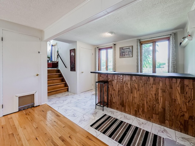 19394 Ingram Dr, Shelby Twp, MI 48038 - kitchen with a textured ceiling, light marble finish flooring, and a kitchen breakfast bar