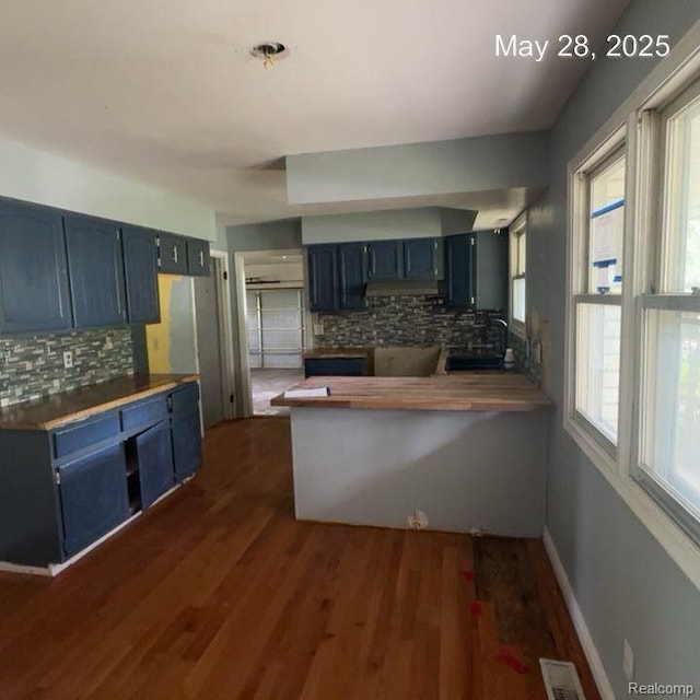1396 Westerrace Dr, Flint, MI 48532 - kitchen with blue cabinets, decorative backsplash, dark wood finished floors, and a peninsula