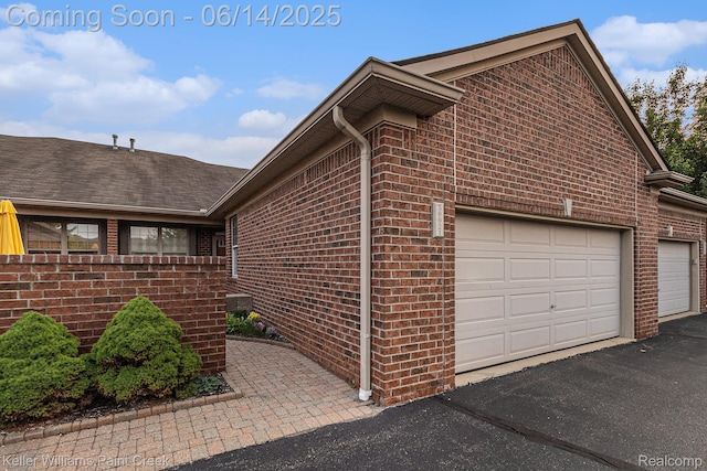 50021 Ludwig Ct, Shelby Twp, MI 48317 - view of side of property with brick siding, a shingled roof, and a garage