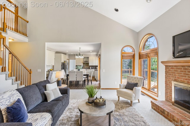 49093 Poppleton Ct, Canton, MI 48187 - living room featuring high vaulted ceiling, stairs, a brick fireplace, a chandelier, and recessed lighting